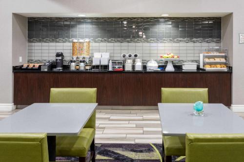 a restaurant with two tables and chairs and a counter at La Quinta by Wyndham Denver Boulder - Louisville in Louisville