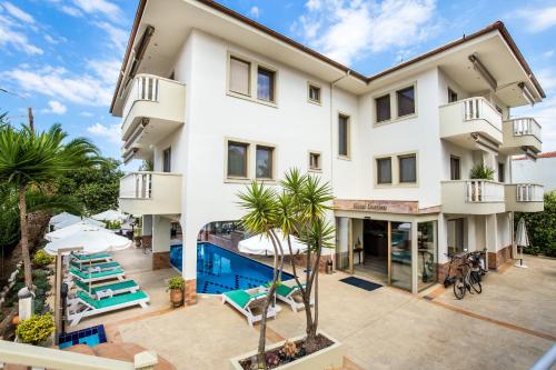 an apartment building with a pool and palm trees at Garden in Limenaria