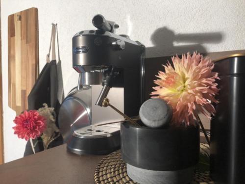 a coffee maker and a flower sitting on a table at Ferienhof Kampfl in Fügen