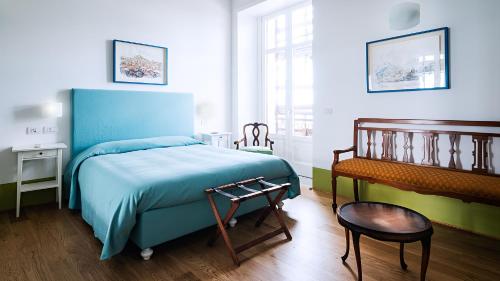 1 dormitorio con 1 cama azul y 1 silla en Donna Giulia, Luxury House, en Salerno