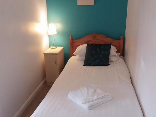 a bed with a white bedspread and pillows at Betty Cottles Inn in Okehampton