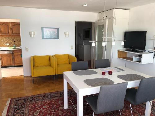 eine Küche und ein Wohnzimmer mit einem Tisch und Stühlen in der Unterkunft Ferienwohnung Grob "Seeblick" in Konstanz