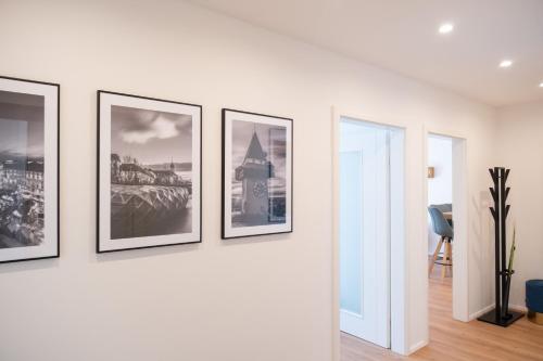 a row of framed photographs on a white wall at MH Living - 5 - Scandinavian Living Dream in Center in Graz