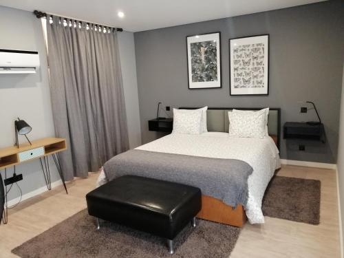 a bedroom with a bed and a black stool at Porto Suites do Marquês in Porto