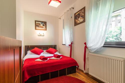 sypialnia z czerwonym łóżkiem z dwoma czerwonymi różami w obiekcie Apartament Olivia Zakopane w Zakopanem