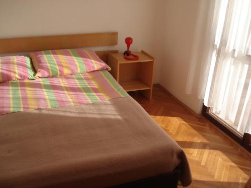 ein Schlafzimmer mit einem Bett, einem Nachttisch und einem Fenster in der Unterkunft Apartments Mia in Starigrad-Paklenica