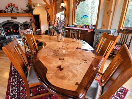 uma mesa de jantar em madeira com cadeiras e um estofados de esteira em Carriage House Accommodations em Girdwood