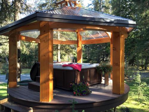 a wooden gazebo with a hot tub at Carriage House Accommodations in Girdwood
