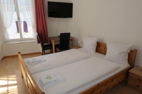 a bedroom with a bed and a table with chairs at Hotel Franziskaner in Chur