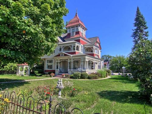 a large house with a turret on top of a yard at Grand Victorian B&B Inn in Bellaire