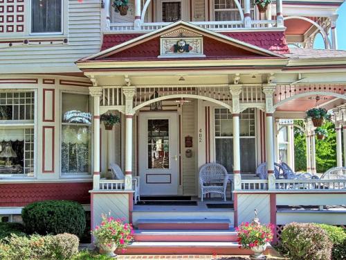 a large house with a porch with a front door at Grand Victorian B&B Inn in Bellaire