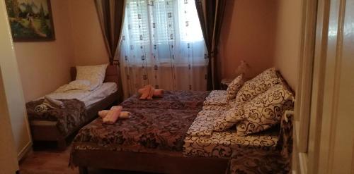 a bedroom with a bed with two stuffed animals on it at Balla House in Tărcaia