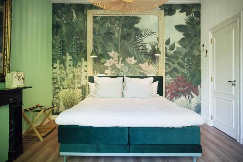 a bedroom with a large bed with a floral wallpaper at MUZE Hotel Utrecht in Utrecht