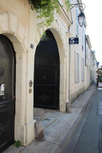 two black doors on the side of a building at 5 Grande Rue in Le Lude