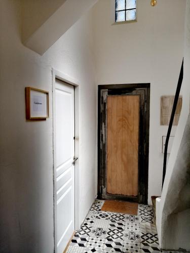 a hallway with a door and a tile floor at La Maison Grivolas Appartements et Maison d'hôtes in Avignon