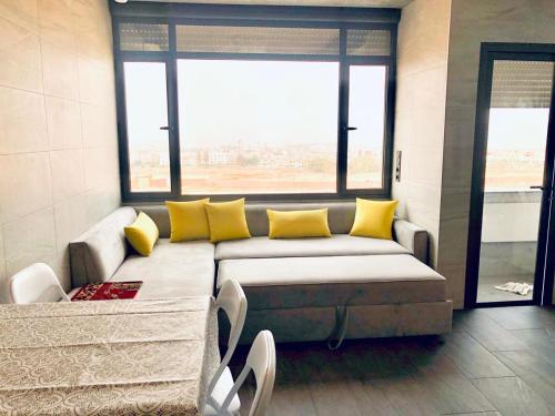 ein Wohnzimmer mit einem Sofa und gelben Kissen in der Unterkunft Scenic Family Apt overlooking Agadir in Agadir