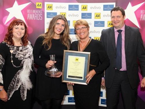 a group of three people holding an award plaque at Grosvenor Lodge Guest House in Christchurch