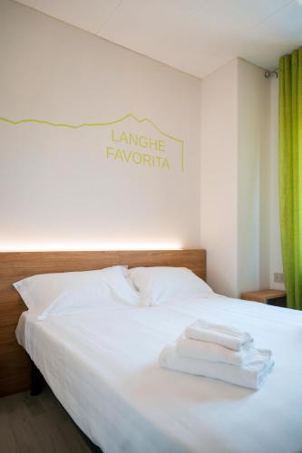 a white bed with towels on top of it at Vino e Turismo in San Defedente di Cervasca