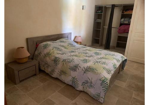 a bedroom with a bed with a blanket with palm leaves at Villa l'Olivier in Cagnes-sur-Mer