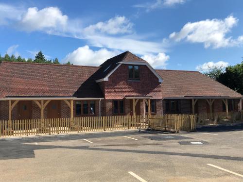 a building with a wooden fence in a parking lot at Hamilton Arms Suites in Midhurst