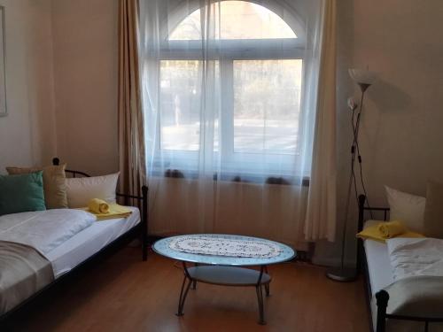 a bedroom with a bed and a table and a window at Harsdörffer Apartment in Nürnberg