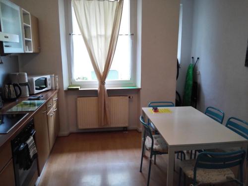 una pequeña cocina con mesa y ventana en Harsdörffer Apartment, en Núremberg