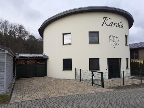 a white building with the word karbala on it at KAMA Ferienhäuser Haus Karola in Wendisch Rietz