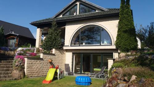 a house with a play equipment in the yard at KAMA Ferienhäuser Haus Kathrin in Wendisch Rietz
