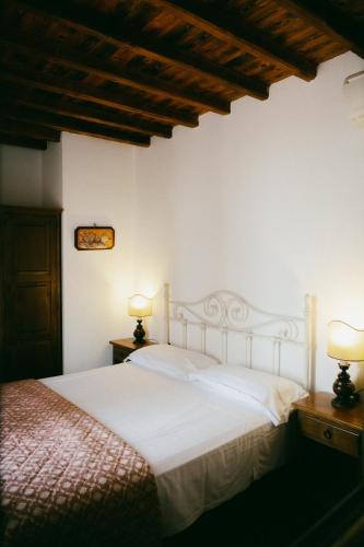 a bedroom with a white bed and two lamps at Fattoria Degli Usignoli in San Donato in Fronzano