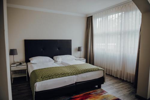 a bedroom with a large bed and a window at Parkhotel Brunauer in Salzburg