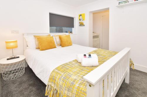 a bedroom with a large white bed with yellow pillows at Townhouse @ Henry Street Crewe in Crewe