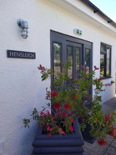 a front door of a house with flowers in a pot at Hensleigh House in Charmouth