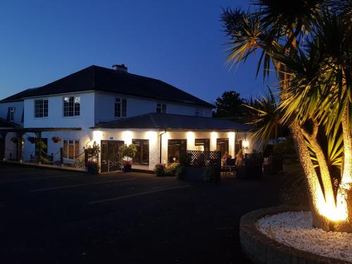 a white building with lights on it at night at Hensleigh House in Charmouth