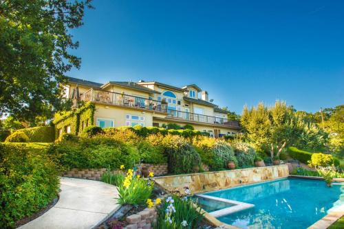 een groot huis met een zwembad in een tuin bij High Ridge Manor in Paso Robles