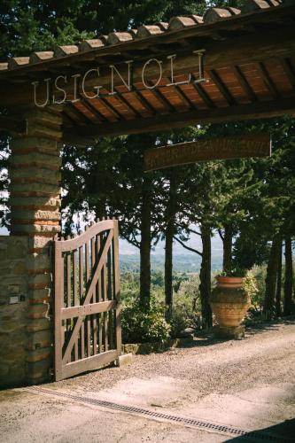 an entrance to a wooden gate with a wooden sign at Fattoria Degli Usignoli in San Donato in Fronzano