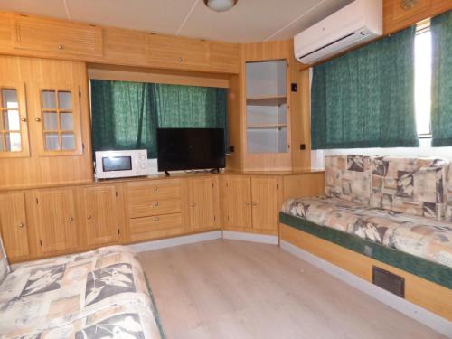 a room with two beds and a flat screen tv at Camping Barraquetes in Sueca