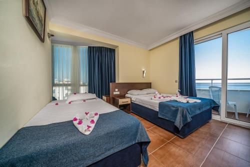 a hotel room with two beds and a balcony at Arsi Blue Beach Hotel in Alanya