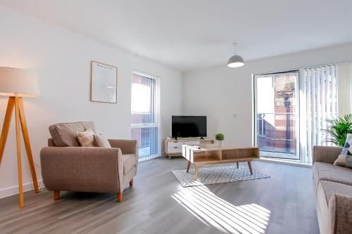 a living room with a couch and a tv at Hilltop Serviced Apartments- Northern Quarter in Manchester