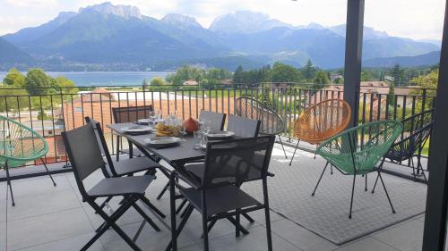 a table and chairs on a balcony with a view at Appartement Laudon in Sévrier