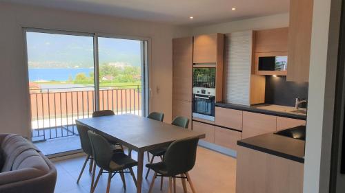 a kitchen and dining room with a table and chairs at Appartement Laudon in Sévrier