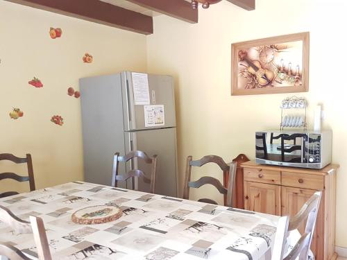 a kitchen with a table and a refrigerator at Petite maison du Tertre in Baneuil
