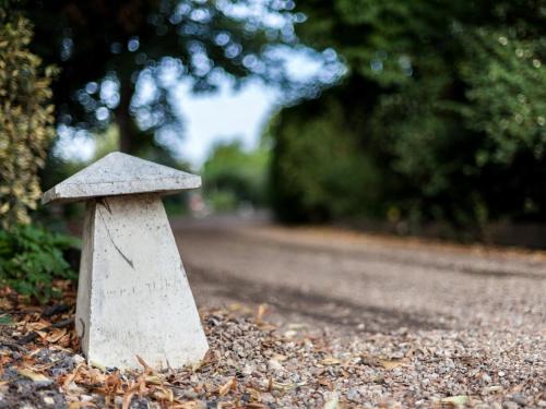 a stone mushroom on the side of a road at Hookwood Lodge in Horley