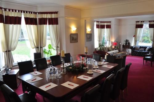 a dining room table with chairs and tables at Hookwood Lodge in Horley
