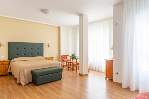 a bedroom with a bed and a table and chairs at Hotel Nautilus in Raxó