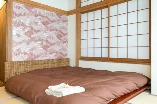 Una cama con dos toallas en una habitación en FromScratch TOKYO, en Tokio