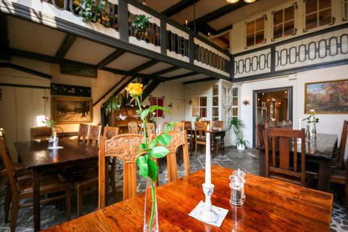 un comedor con una mesa con un jarrón de flores. en Hotel Haase en Lübeck