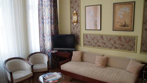 a living room with a couch and a tv at HOTEL alt lüneburger Kutscherstuben in Lüneburg