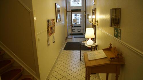 a hallway with a stairway with a table and a lamp at HOTEL alt lüneburger Kutscherstuben in Lüneburg