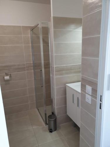 La salle de bains est pourvue d'une douche avec une porte en verre. dans l'établissement COTE VILLAGE, à Nice