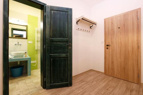 a bathroom with a black door and a sink at Apartmány pod Mariánskými schody in Albrechtice v Jizerských horách